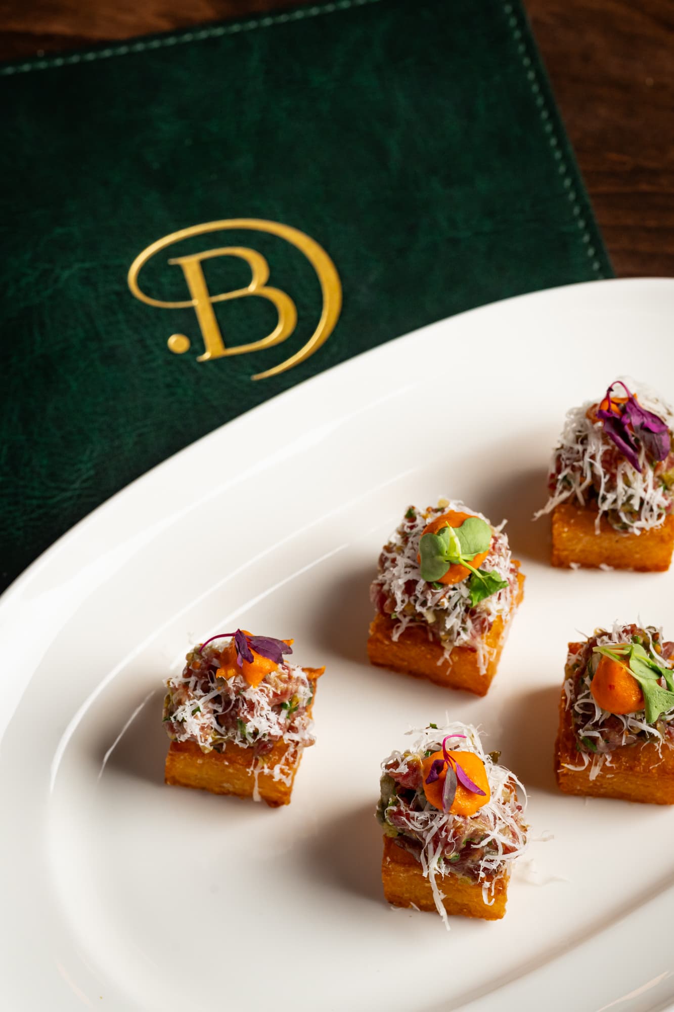 Tuna tartare bites on crispy polenta with The Berczy monogram — a taste of what earned us a spot on foodism's best restaurants list