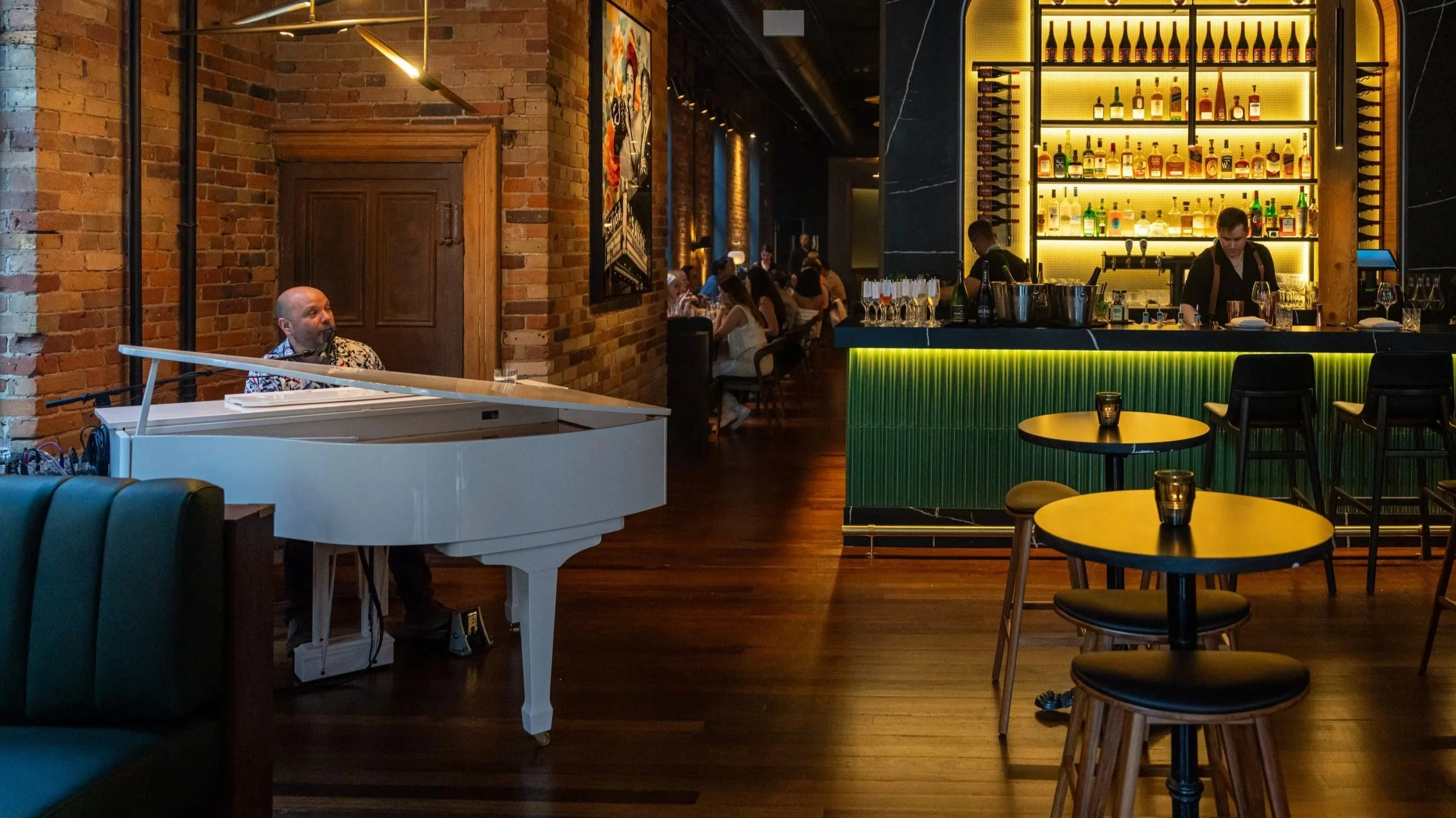Pianist at the white grand piano beside the marble bar at The Berczy Tavern